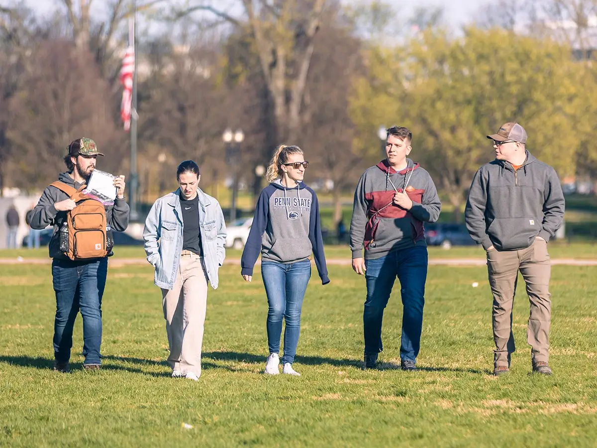 A group of students walking on a lawn